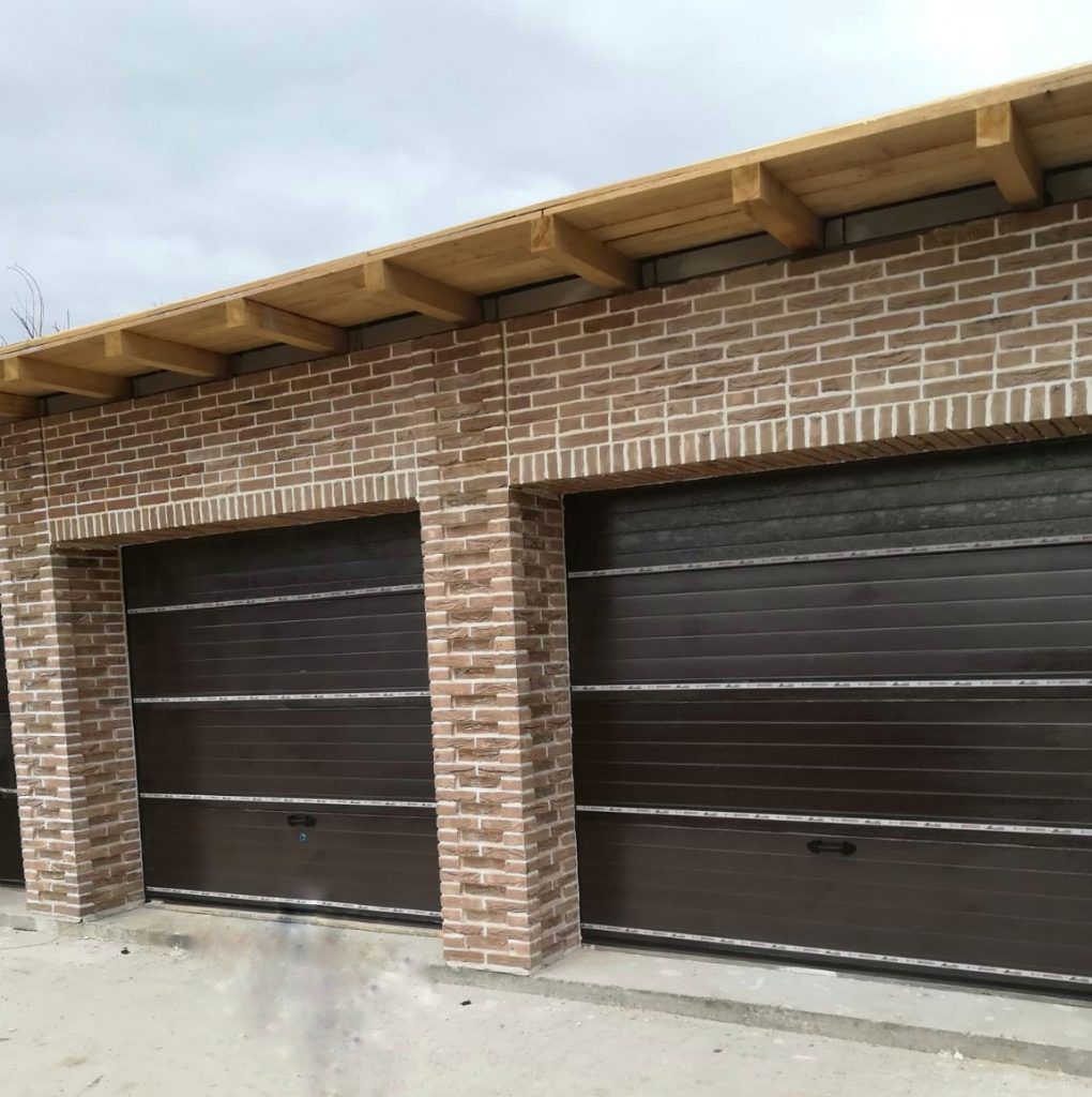 Ușă de garaj tip rulou maro montată sub carport metalic — proiect TERMOCLASS